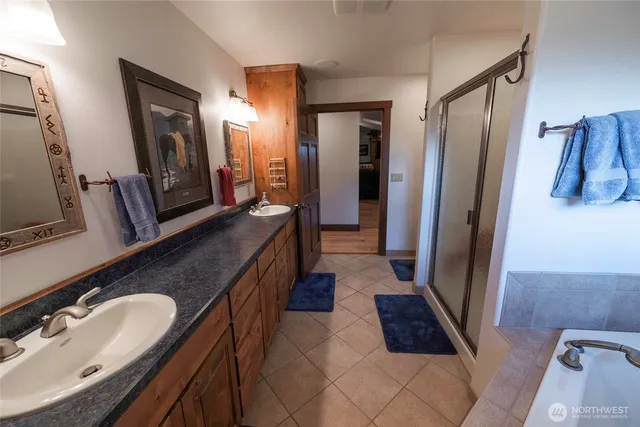 a bathroom with double vanity and a mirror