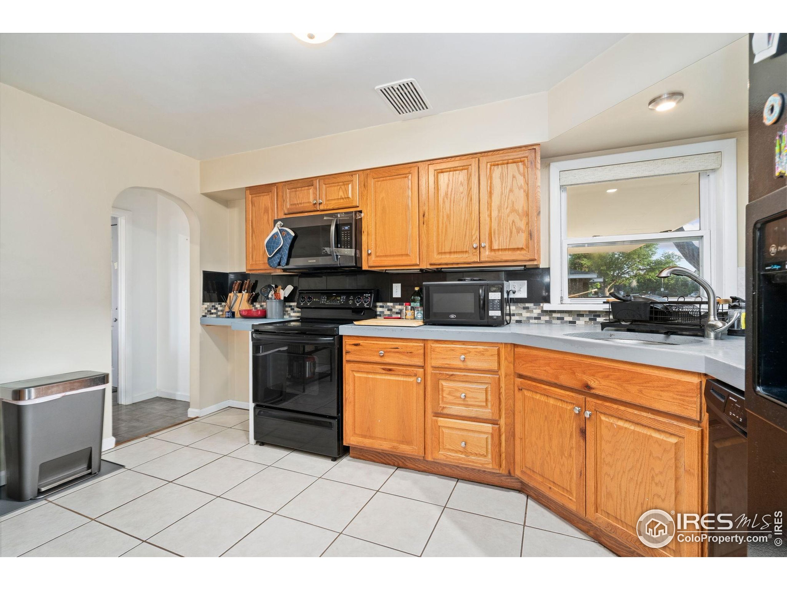 2000 50th Avenue Greeley, CO 80634 - Photo 9 of 34 a kitchen with stainless steel appliances granite countertop a stove a sink and a microwave