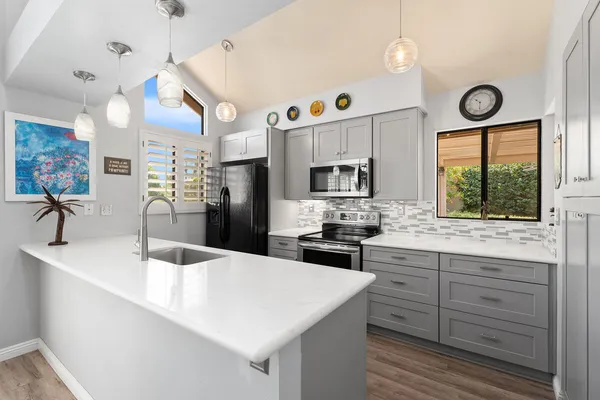 a kitchen with stainless steel appliances kitchen island granite countertop a sink a stove cabinets a dining table and chairs
