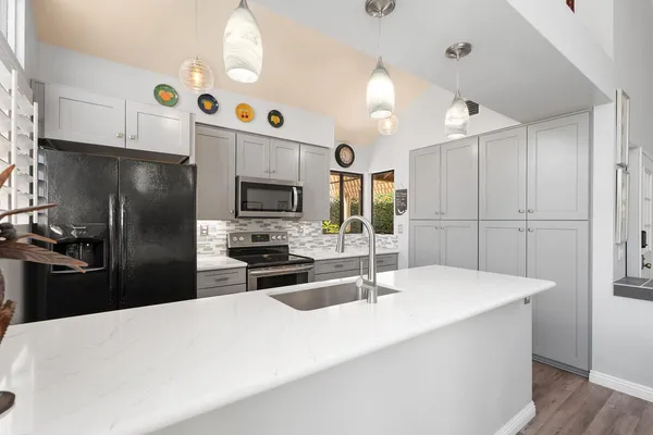 a kitchen with a sink stainless steel appliances a refrigerator and a sink