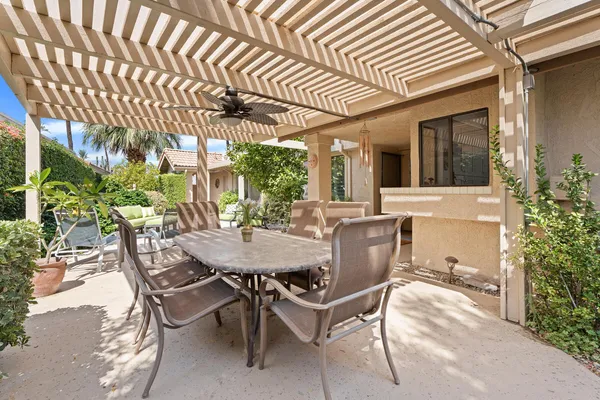 a view of a patio with table and chairs and potted plants