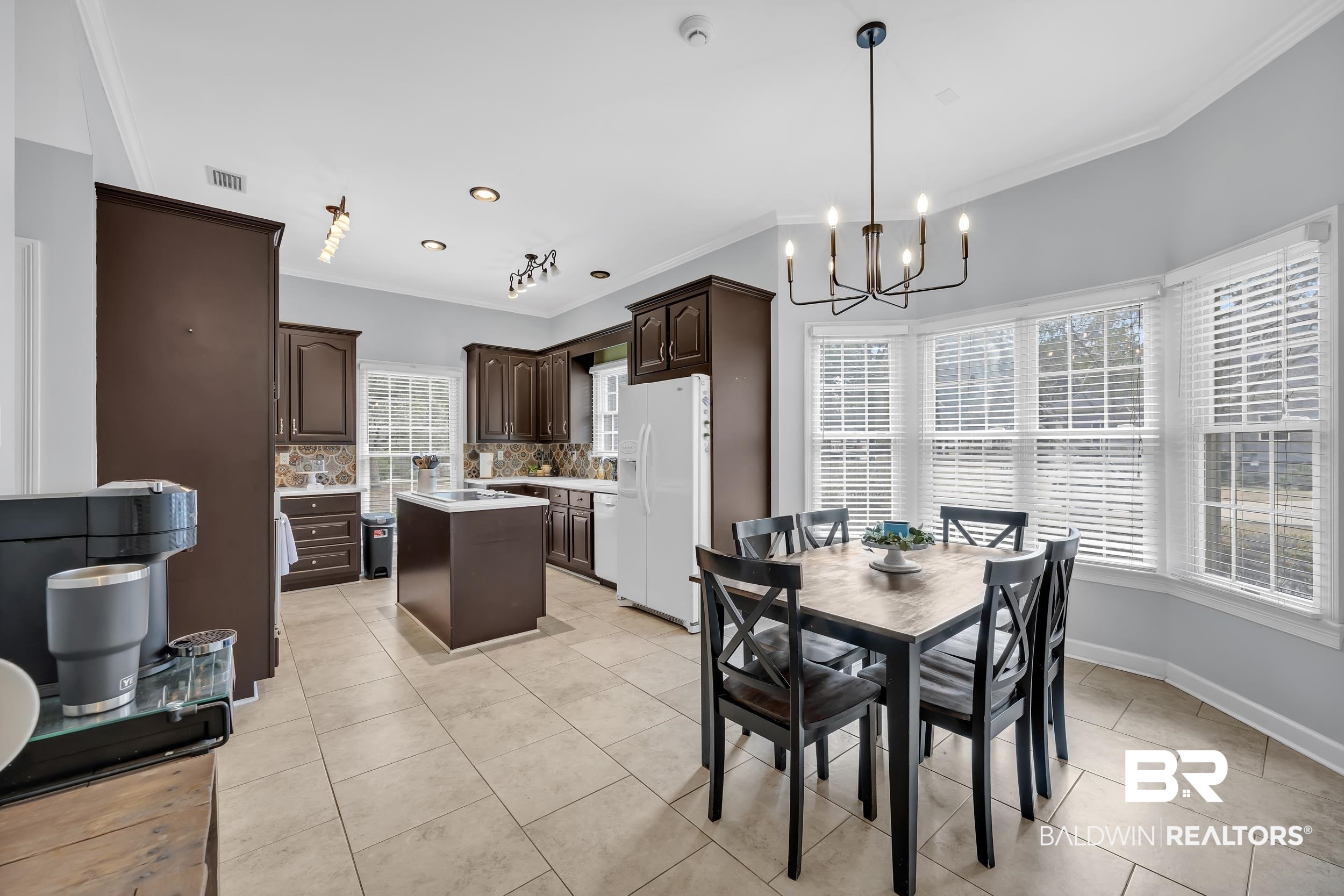 2858 Postoak Circle Mobile, AL 36693 - Photo 16 of 32 Dining space featuring crown molding, light tile patterned flooring, and a chandelier