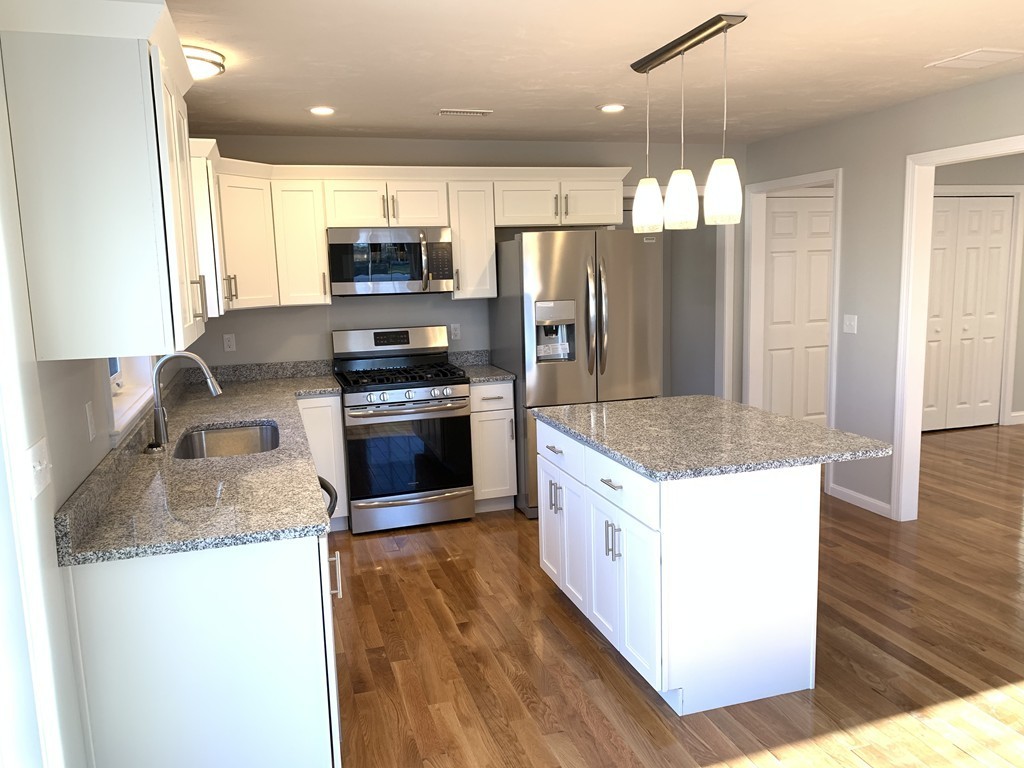 11 Mendon Road, Unit A Attleboro, MA 02703 - Photo 11 of 24 a kitchen with stainless steel appliances granite countertop a refrigerator a stove top oven a sink and dishwasher