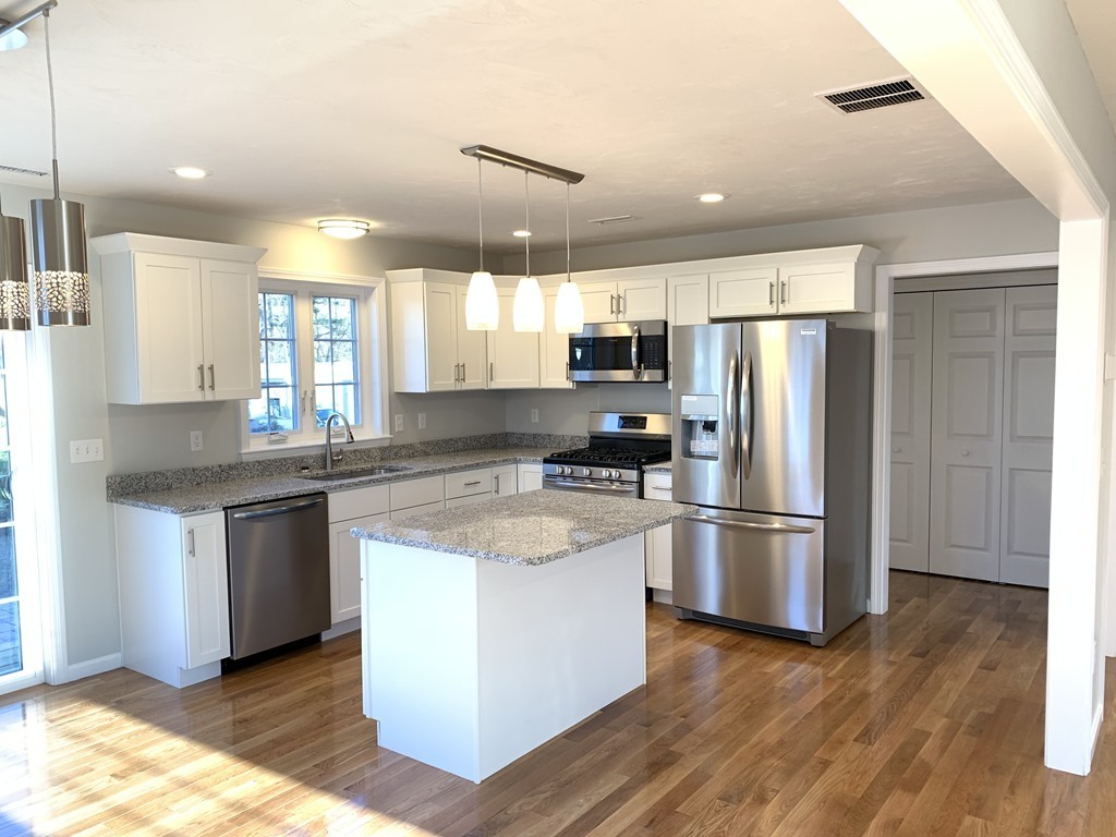11 Mendon Road, Unit A Attleboro, MA 02703 - Photo 13 of 24 a kitchen with stainless steel appliances granite countertop a refrigerator a stove a sink and a microwave
