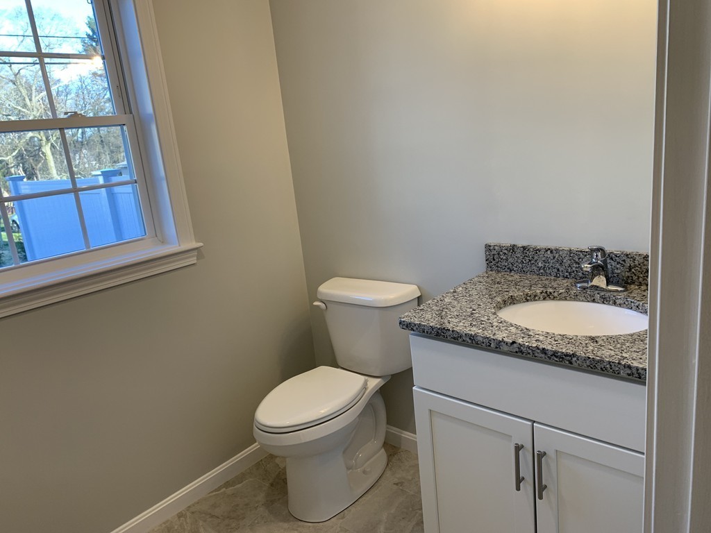 11 Mendon Road, Unit A Attleboro, MA 02703 - Photo 15 of 24 a bathroom with a granite countertop toilet and a sink