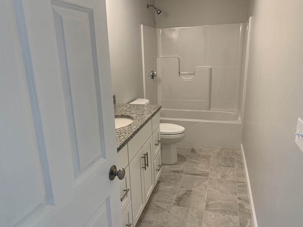 11 Mendon Road, Unit A Attleboro, MA 02703 - Photo 19 of 24 a bathroom with a granite countertop sink toilet and shower