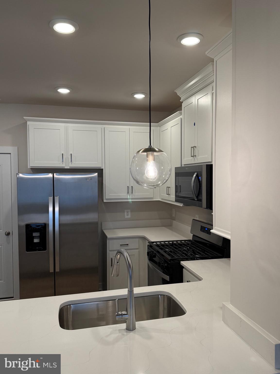 45203 Drowes Terrace Sterling, VA 20166 - Photo 14 of 19 a kitchen with stainless steel appliances kitchen island granite countertop a refrigerator a oven a sink a counter and chairs