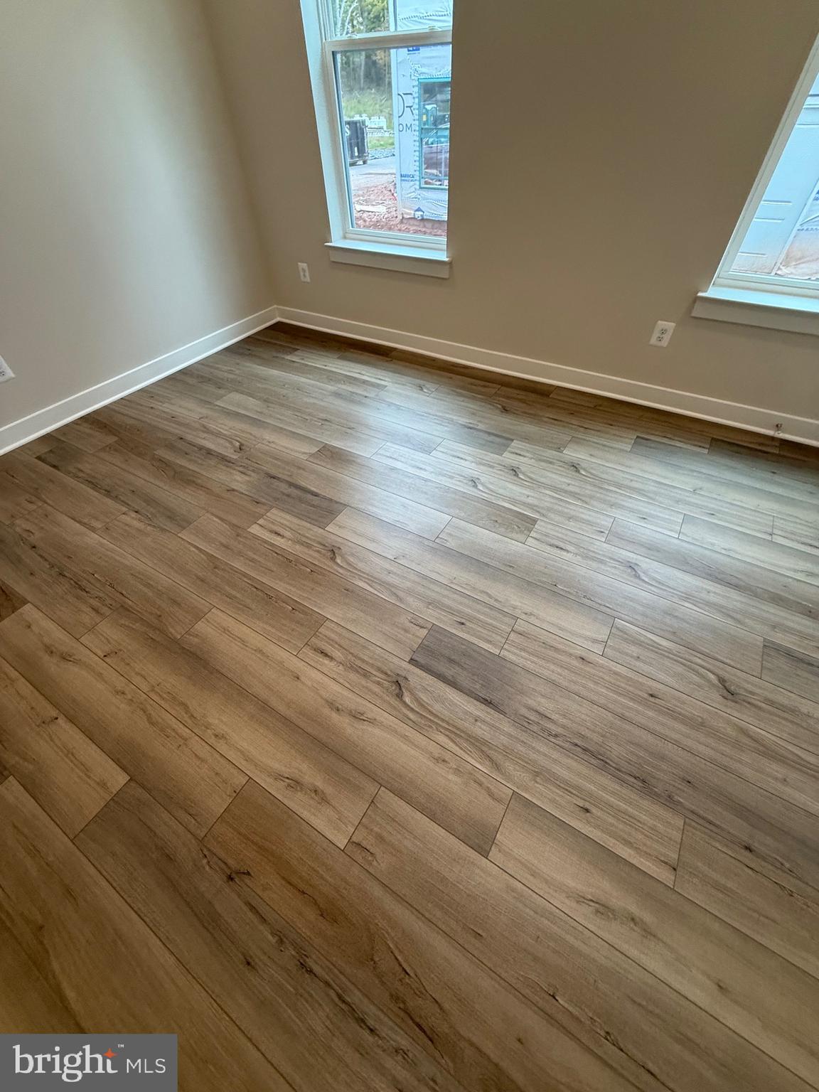 45203 Drowes Terrace Sterling, VA 20166 - Photo 7 of 19 an empty room with wooden floor and windows