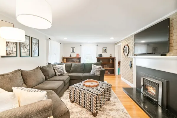 a living room with furniture a flat screen tv and a fireplace