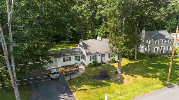 a front view of a house with a garden and trees
