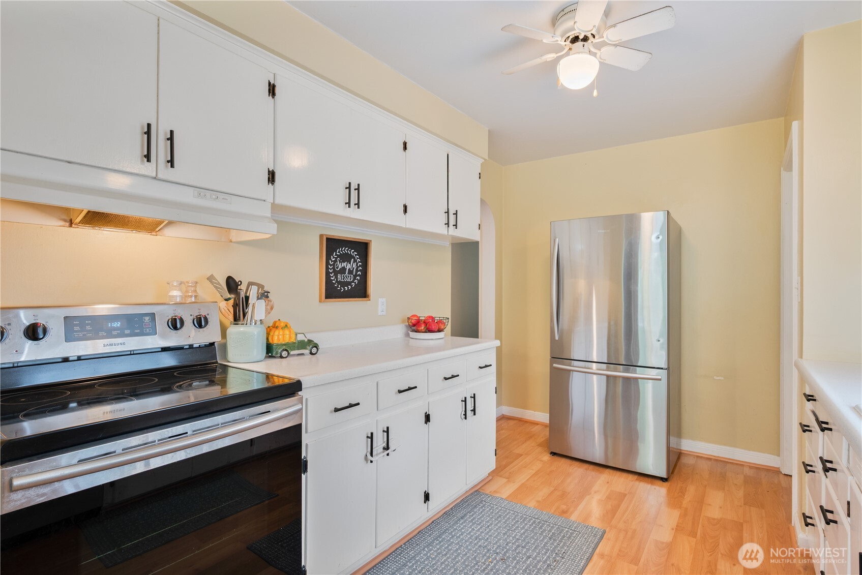 467 19th Avenue Longview, WA 98632 - Photo 10 of 30 a kitchen with kitchen island white cabinets and stainless steel appliances