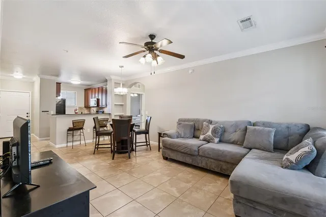 a living room with furniture kitchen view and a chandelier
