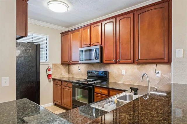 a kitchen with stainless steel appliances granite countertop a refrigerator stove and sink