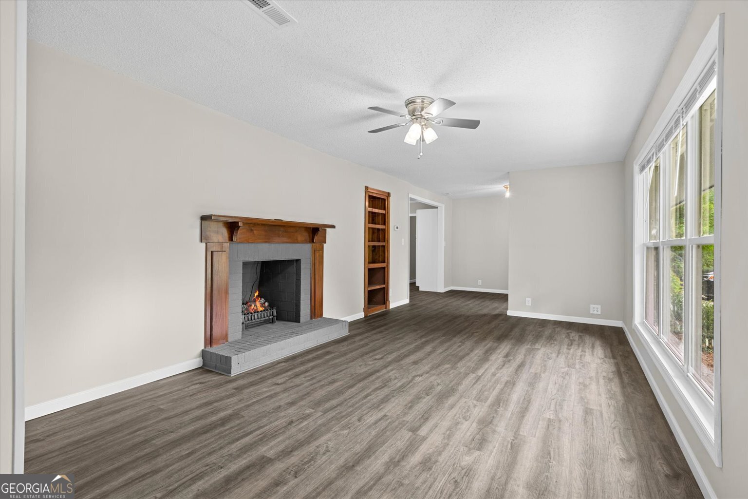552 Dantzler Circle Dalton, GA 30721 - Photo 5 of 20 an empty room with wooden floor fireplace and windows