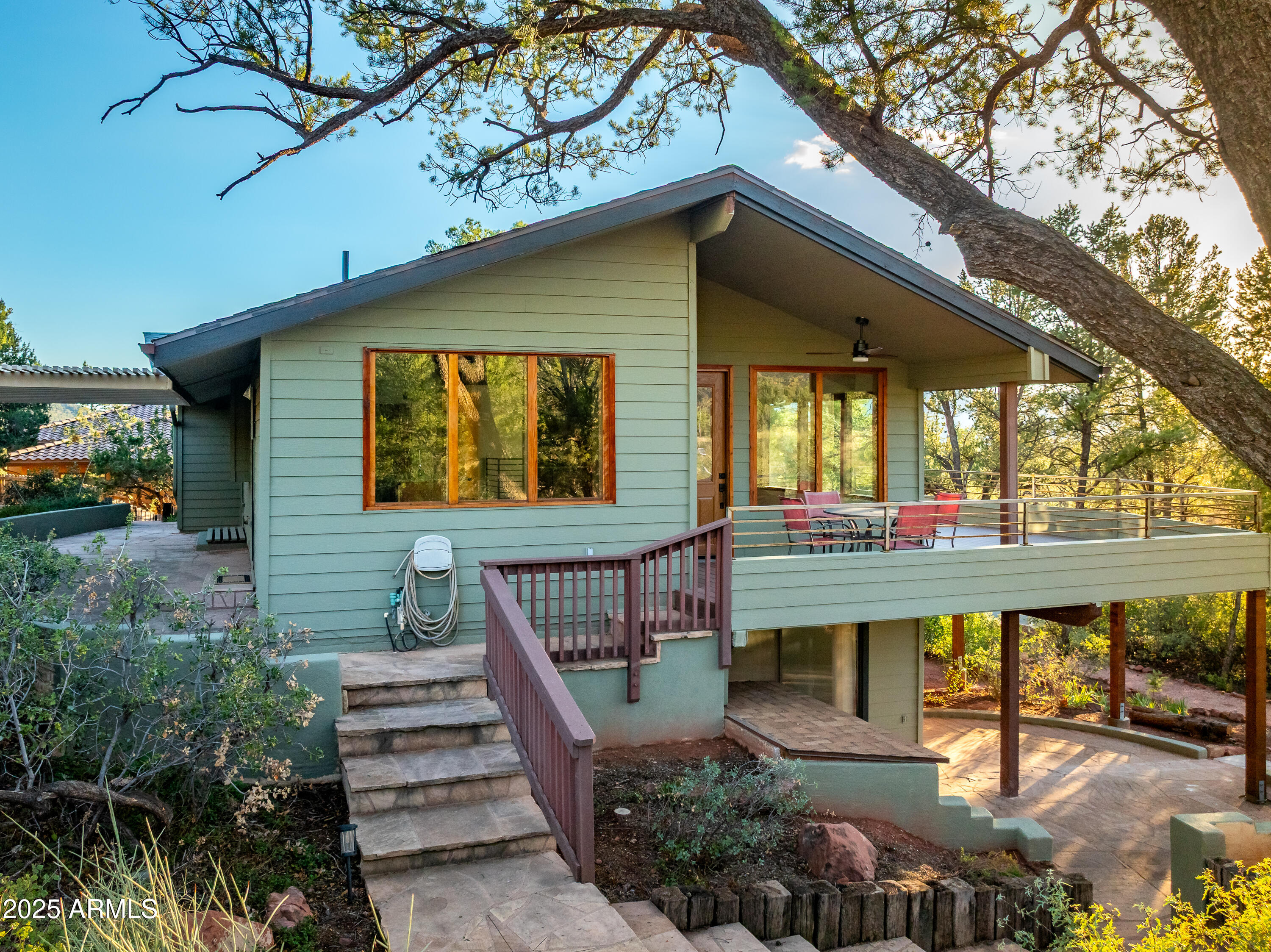 1050 Lee Mountain Road Sedona, AZ 86351 - Photo 25 of 78 a view of a house with large windows and a small yard