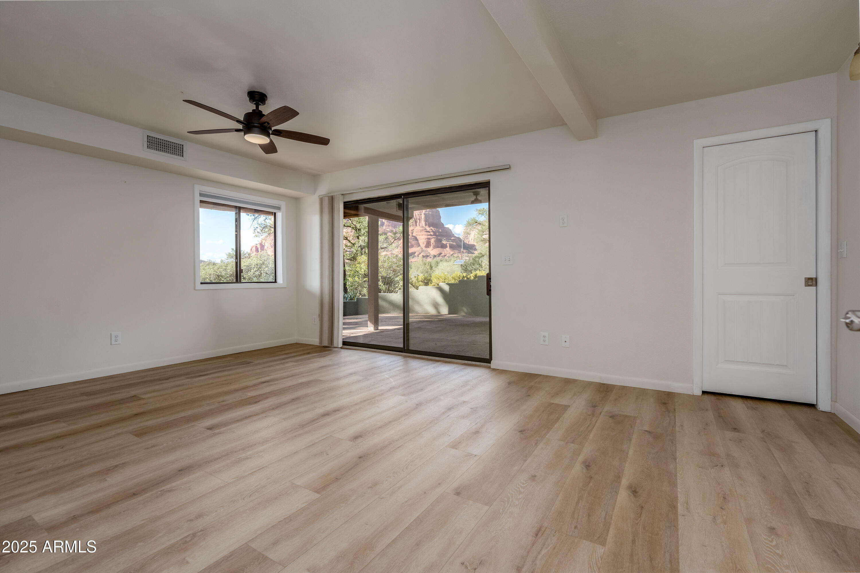 1050 Lee Mountain Road Sedona, AZ 86351 - Photo 72 of 78 an empty room with wooden floor fan and windows