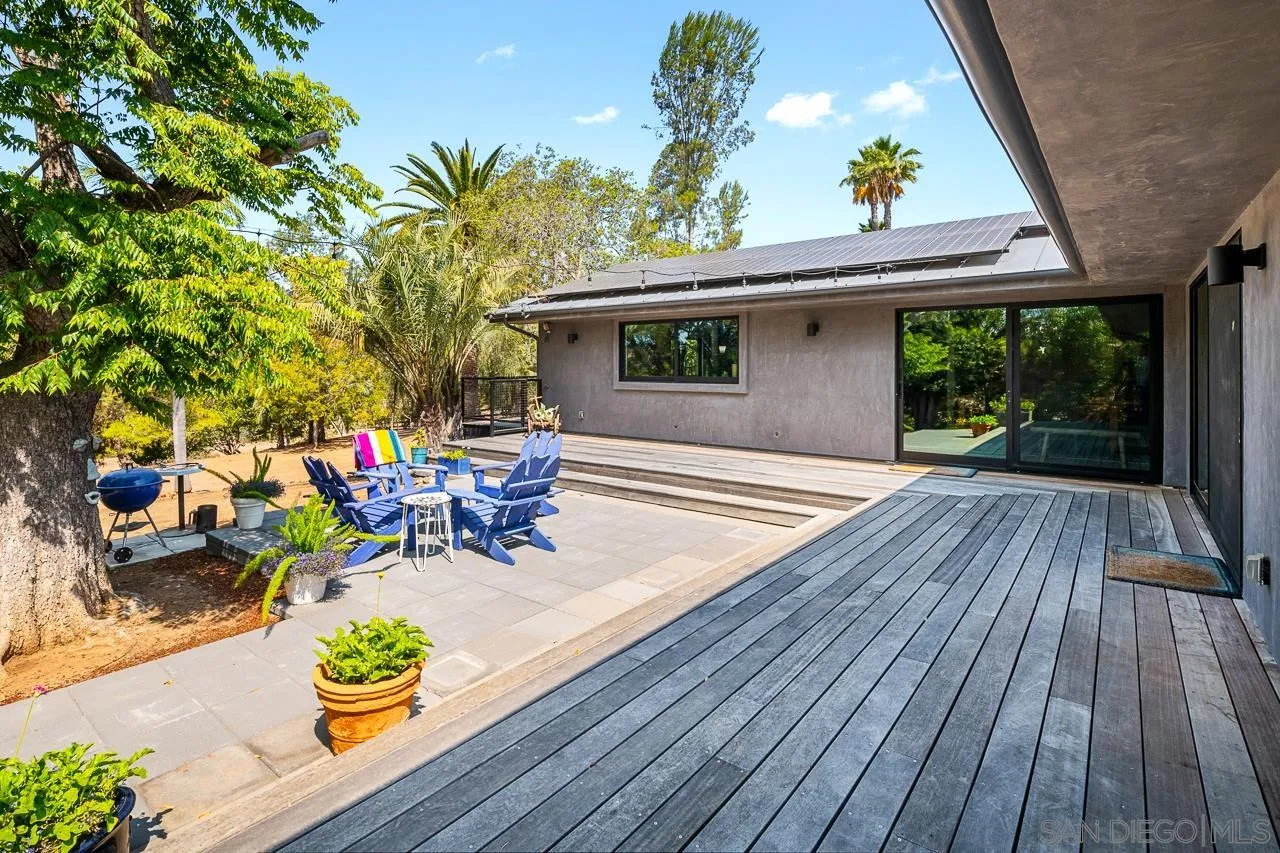 17436 Rancho Del Rio Rancho Santa Fe, CA 92067 - Photo 36 of 44 a view of a patio with table and chairs potted plants with wooden floor and fence