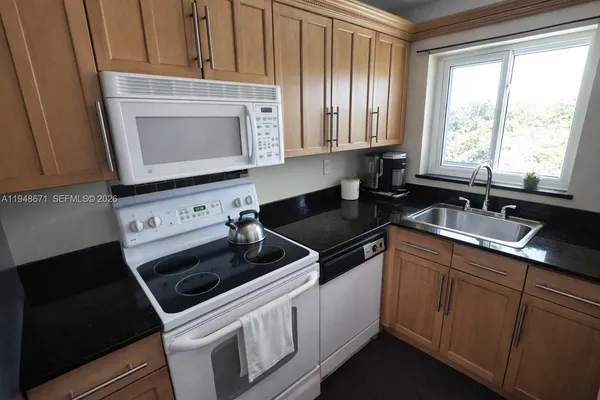 a kitchen with granite countertop a stove and a sink