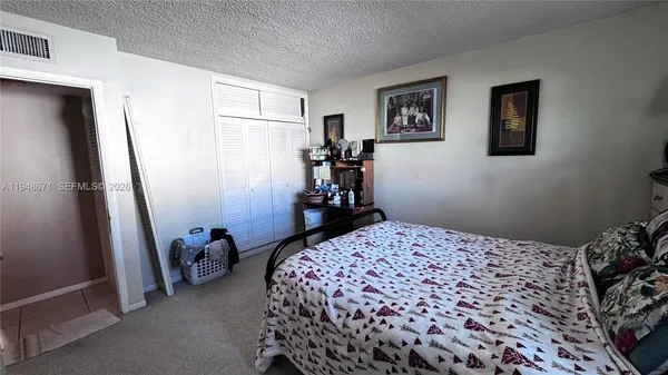 a bedroom with a bed and a refrigerator