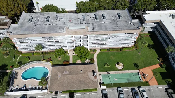an aerial view of a swimming pool with outdoor space and seating area