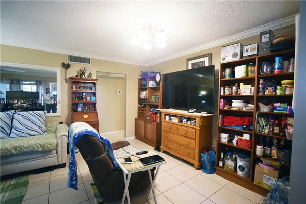 a living room with furniture a flat screen tv and a bookshelf