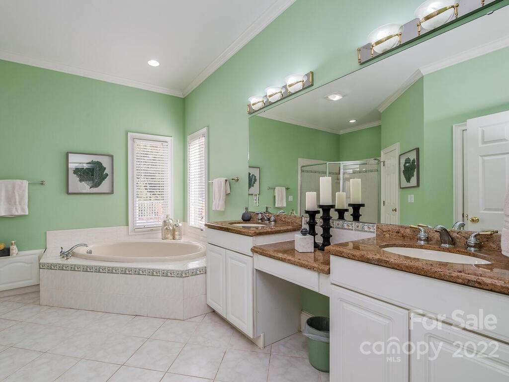 4101 High Ridge Road Charlotte, NC 28270 - Photo 12 of 38 a bathroom with a tub sink a mirror and vanity