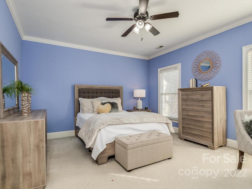 4101 High Ridge Road Charlotte, NC 28270 - Photo 18 of 38 a bedroom with a bed dresser and a chandelier