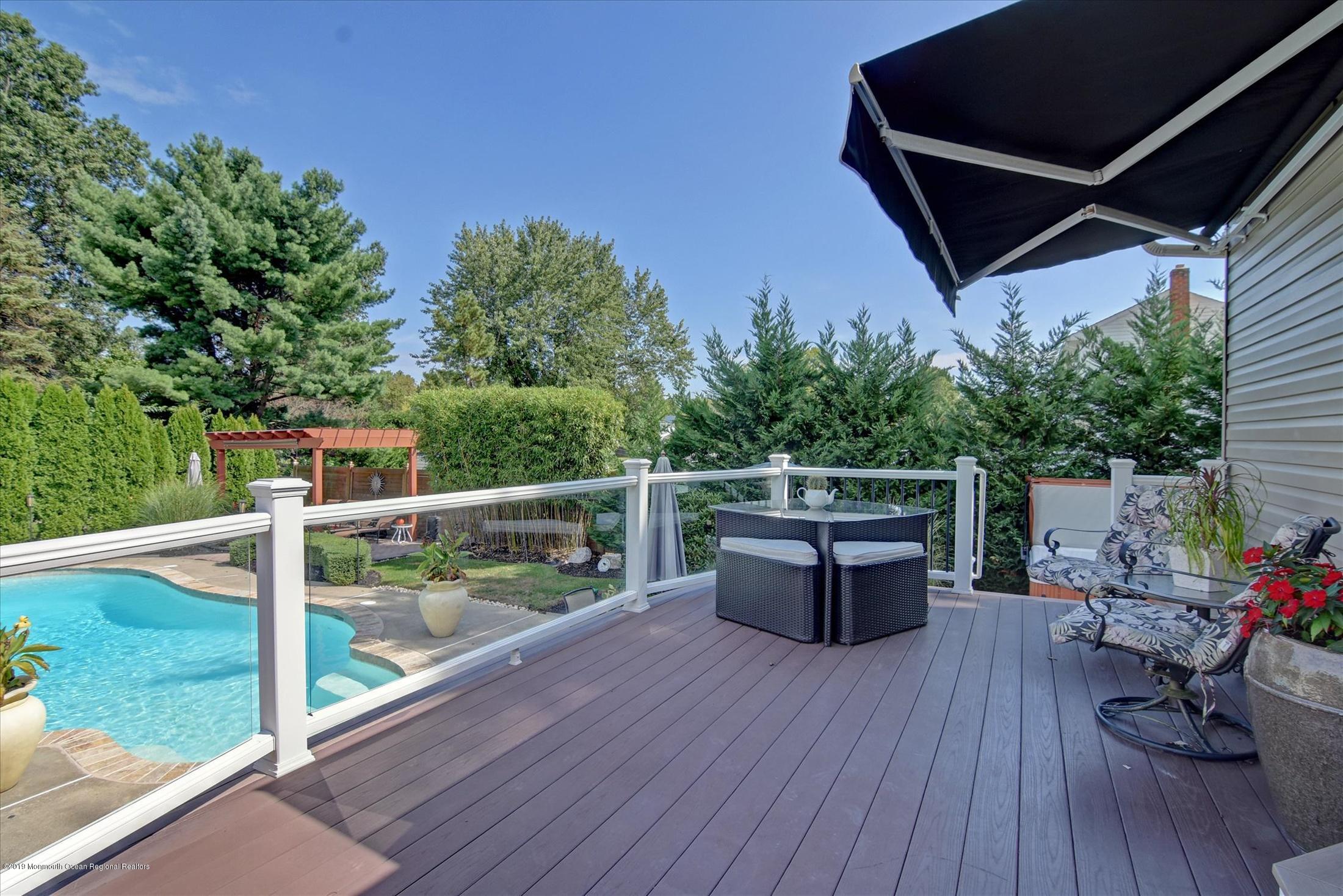 244 Elton Adelphia Road Freehold, NJ 07728 - Photo 35 of 46 a roof deck with table and chairs and wooden floor