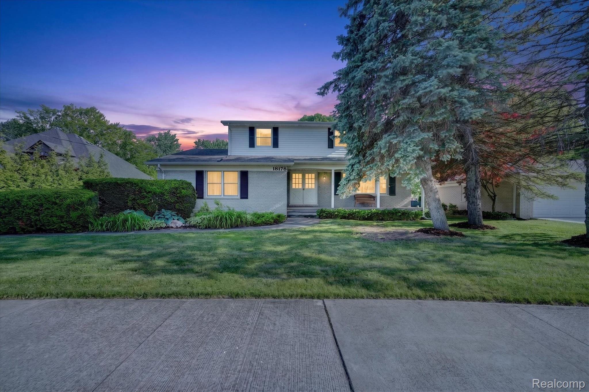 Traditional-style residence featuring a light-colored brick facade and dark window shutters