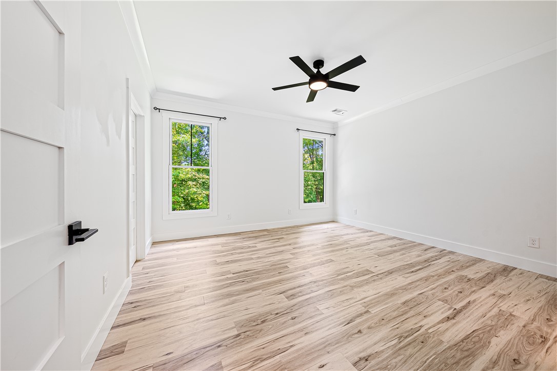 516 Winding Way Hartwell, GA 30643 - Photo 14 of 50 A tranquil, naturally illuminated bedroom awaits with warm wood flooring and a modern ceiling fan.