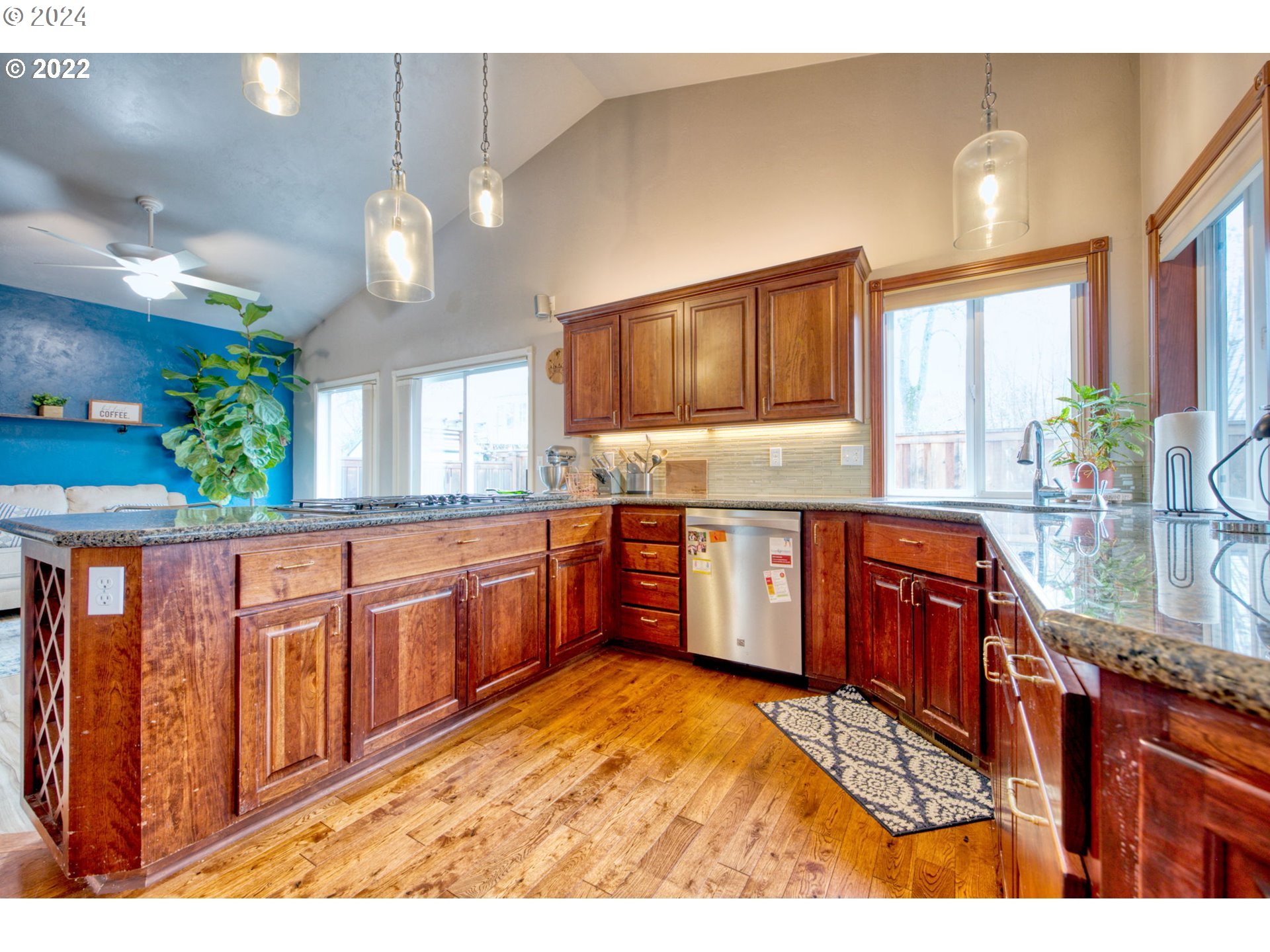 1425 Gilham Road Eugene, OR 97401 - Photo 8 of 30 a large kitchen with granite countertop a stove a sink and dishwasher wooden cabinets with large window