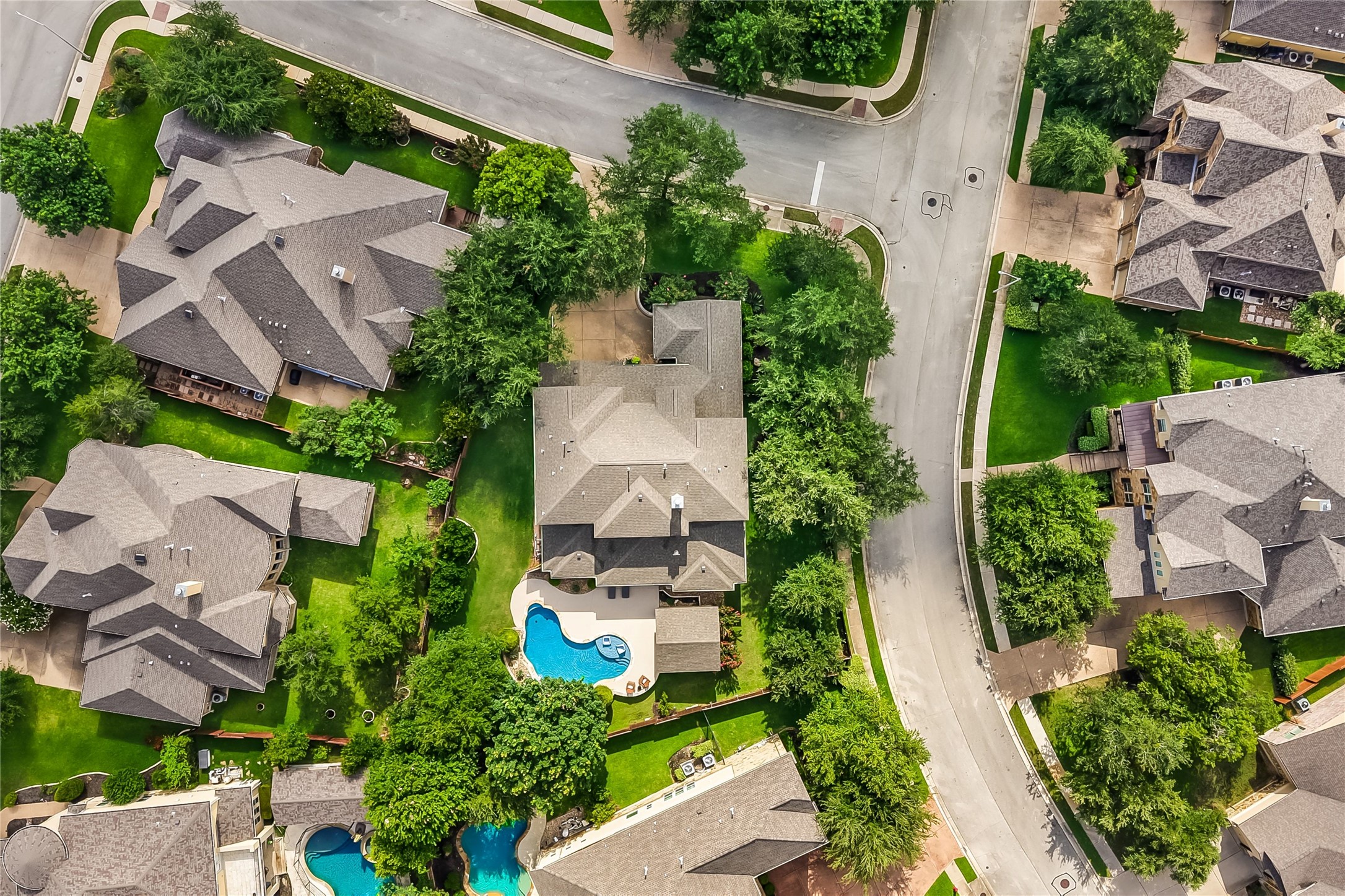 401 Bluff View Road Cedar Park, TX 78613 - Photo 38 of 40 An aerial perspective reveals a private pool nestled in a verdant backyard, surrounded by established trees and a winding street.
