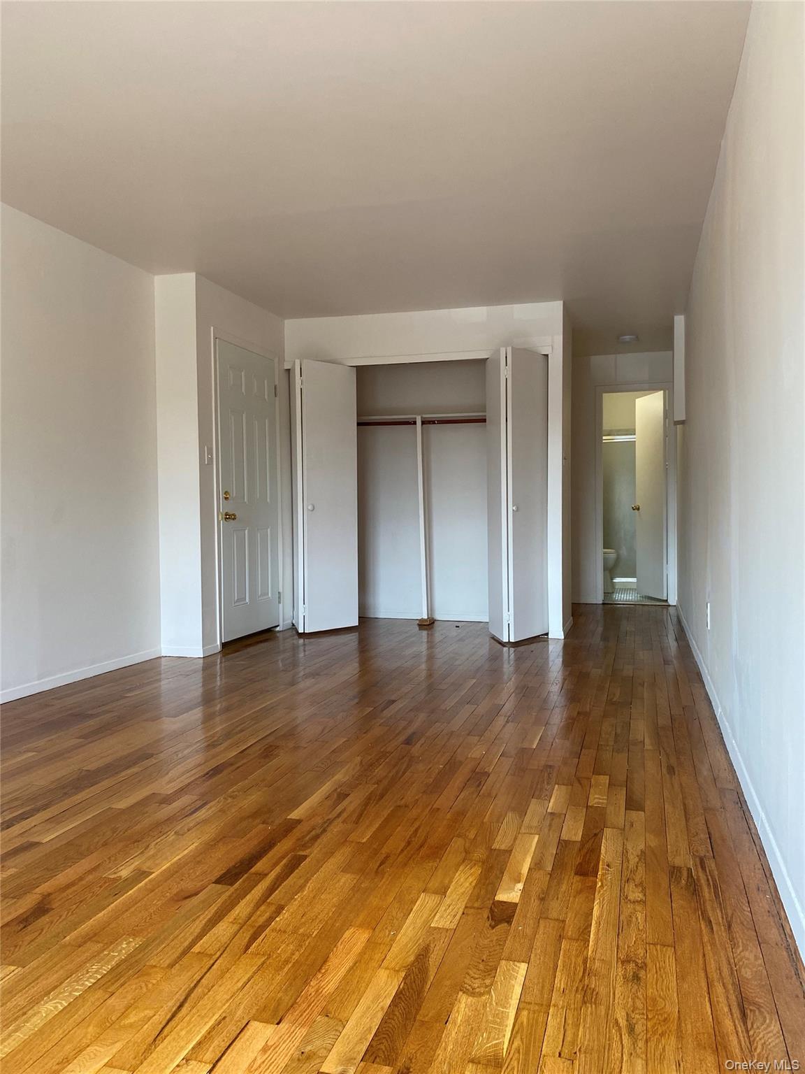 84-24 98th Street, Unit 1 Queens, NY 11421 - Photo 11 of 22 a view of empty room with wooden floor