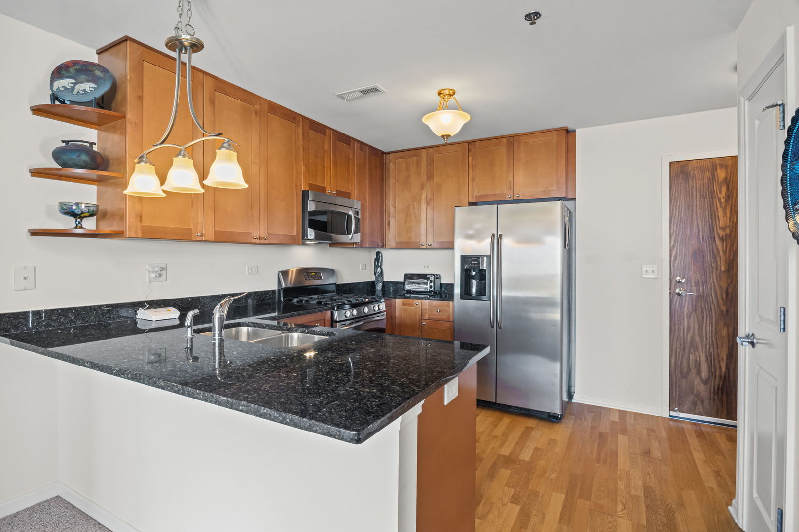 1199 East Port Clinton Road, Unit 601 Vernon Hills, IL 60061 - Photo 3 of 13 a kitchen with granite countertop a refrigerator a sink a stove and microwave