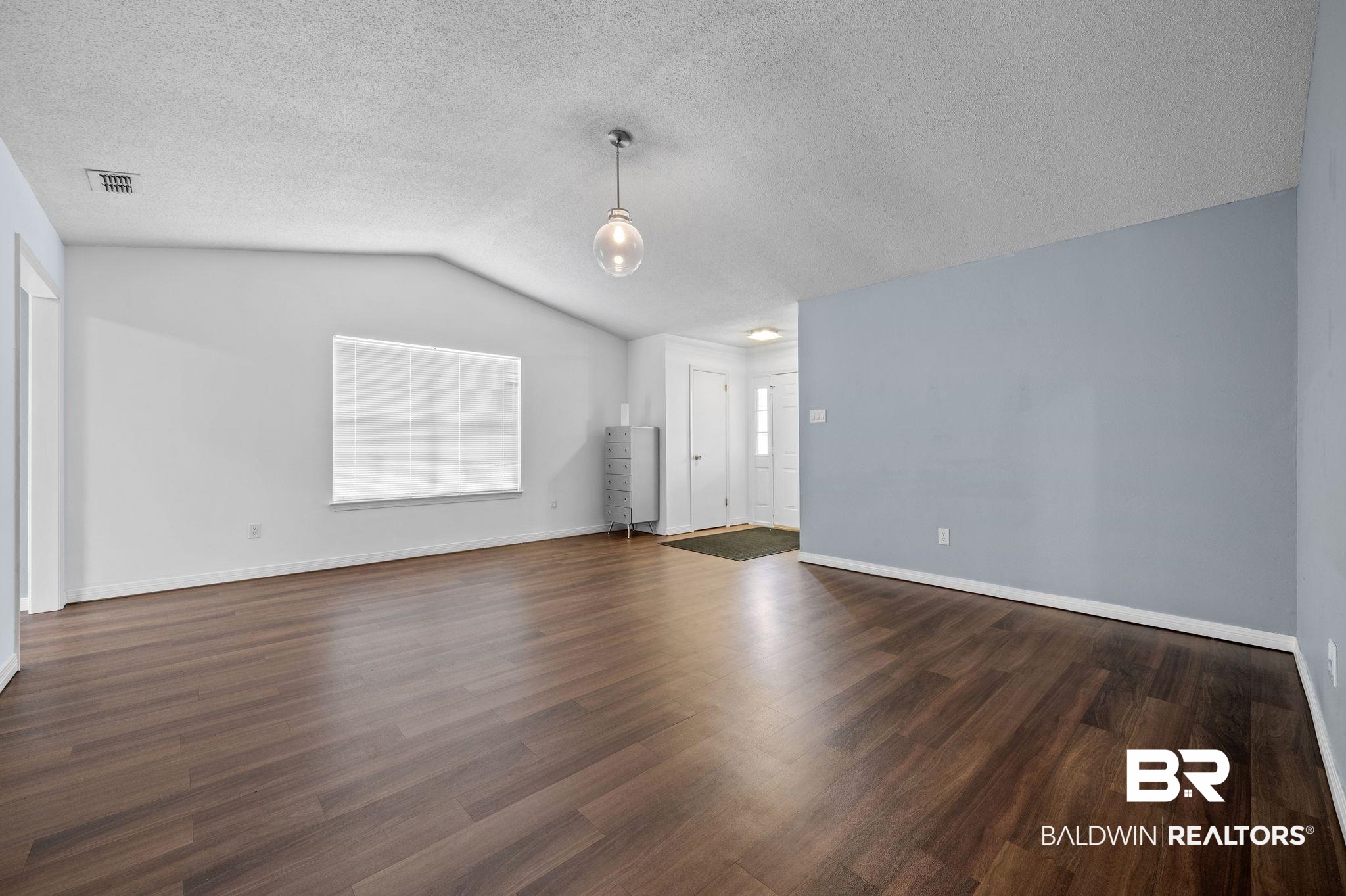 3716 Pepper Ridge Drive Mobile, AL 36693 - Photo 5 of 20 Unfurnished living room with lofted ceiling, a textured ceiling, and dark hardwood / wood-style flooring