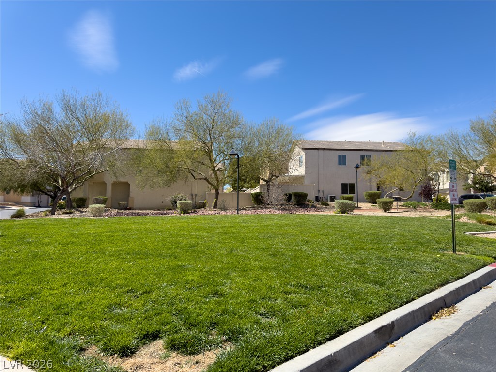 9456 Grandview Spring Avenue Las Vegas, NV 89166 - Photo 44 of 49 Green open space with mature trees provides a welcoming buffer to residences under a vast sky.