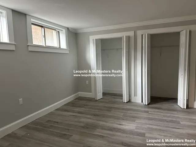 an empty room with wooden floor and a window