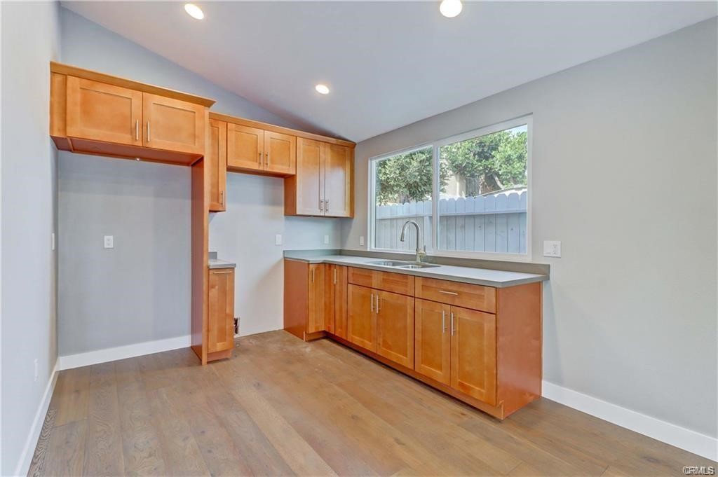 409 Olive Street, Unit B Placentia, CA 92870 - Photo 3 of 11 a kitchen with stainless steel appliances granite countertop a stove a sink and a refrigerator with wooden floors