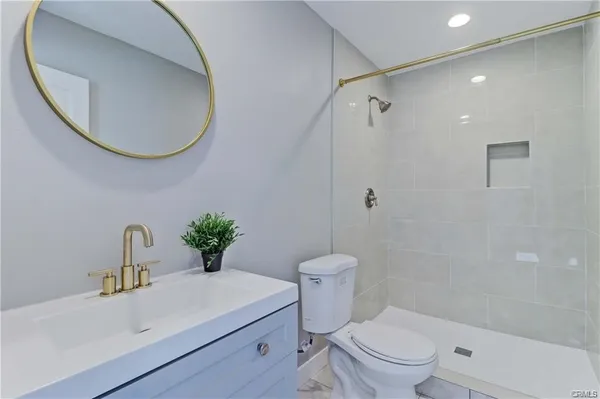 a bathroom with a sink mirror toilet and shower