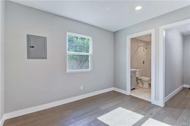 an empty room with wooden floor and a window