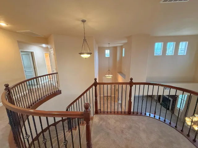 a view of staircase with railing and a chandelier