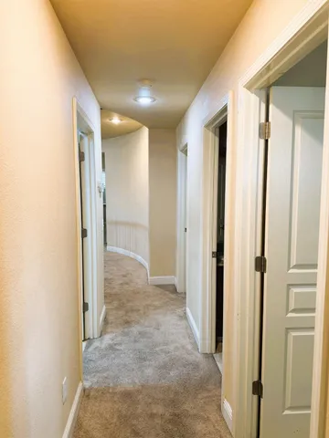 a view of a hallway with wooden shelves