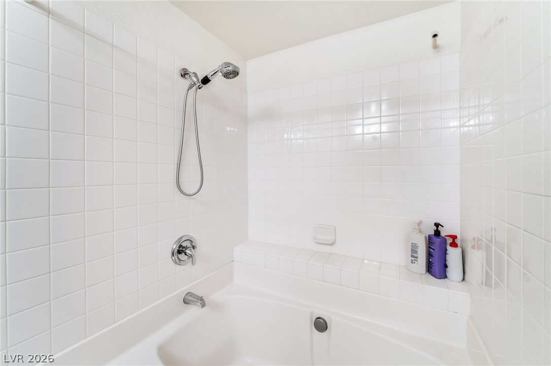 3145 East Flamingo Road, Unit 1092 Las Vegas, NV 89121 - Photo 17 of 33 Relax in a soaking tub with an integrated tiled surround, featuring a handheld shower head and crisp, white subway tiling.