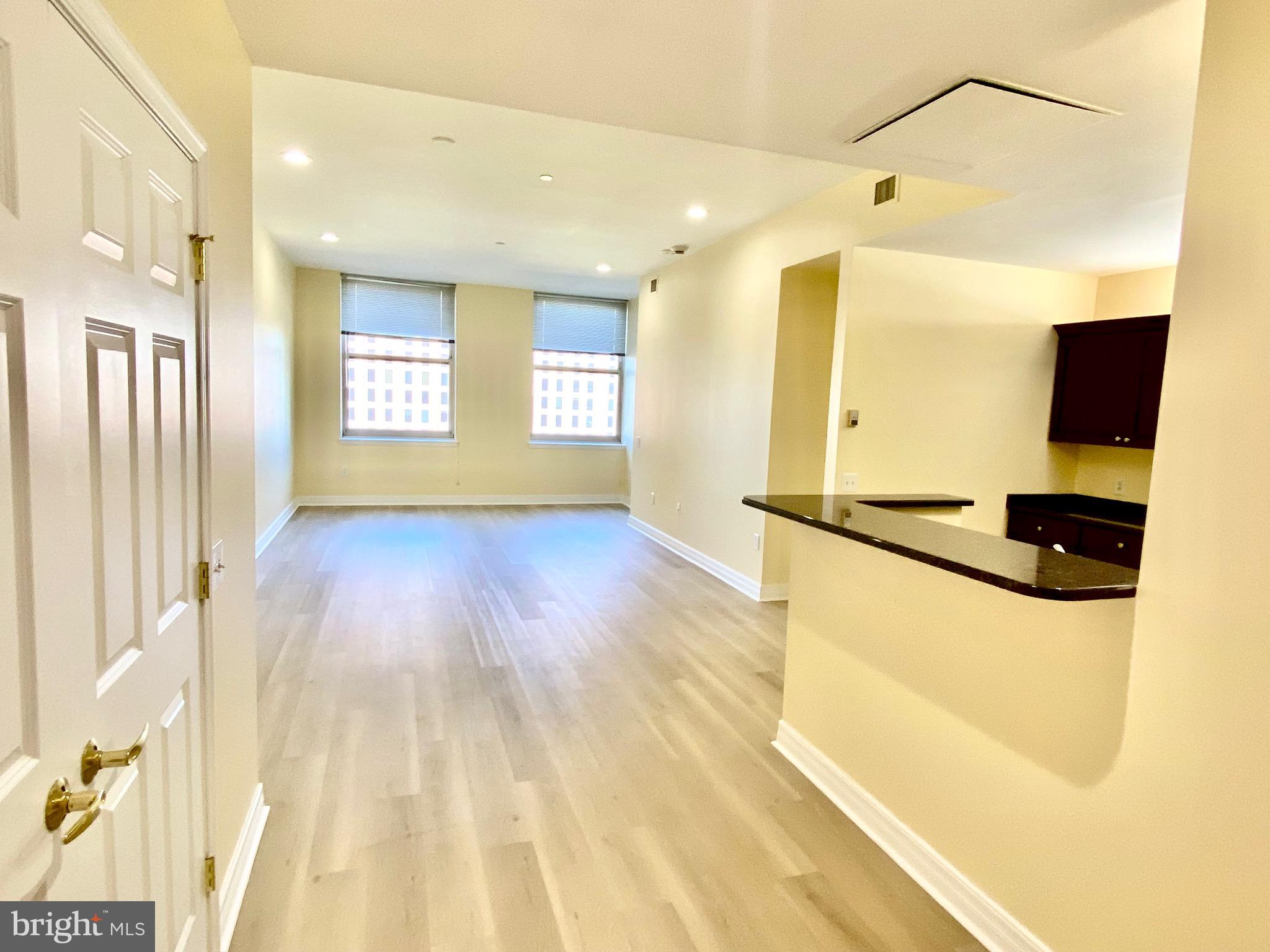 a view of a room with a window and wooden floor