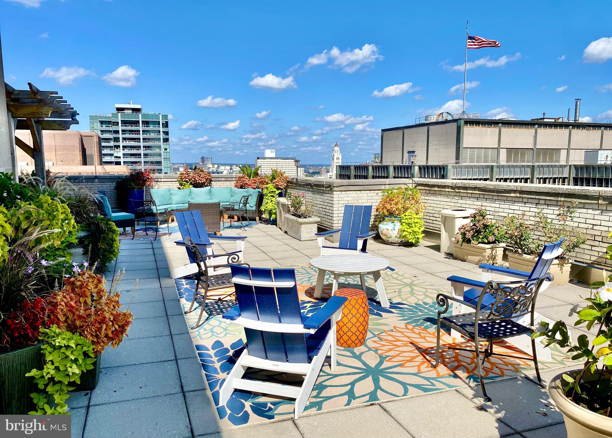 1600-18 Arch Street, Unit 803 Philadelphia, PA 19103 - Photo 31 of 34 a roof deck with dining table and chairs with potted plants
