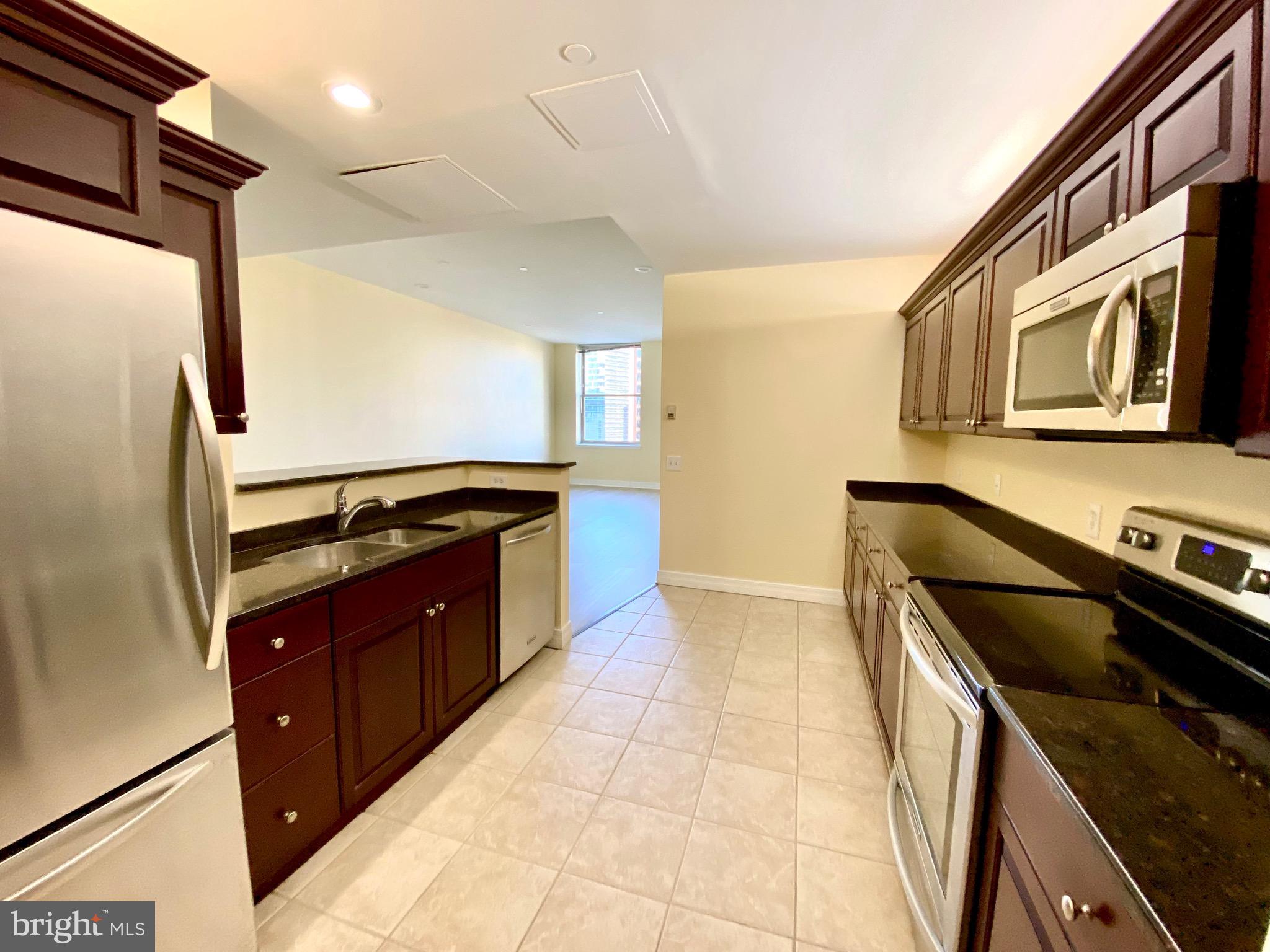 1600-18 Arch Street, Unit 803 Philadelphia, PA 19103 - Photo 5 of 34 a kitchen with stainless steel appliances granite countertop a stove a sink and a microwave