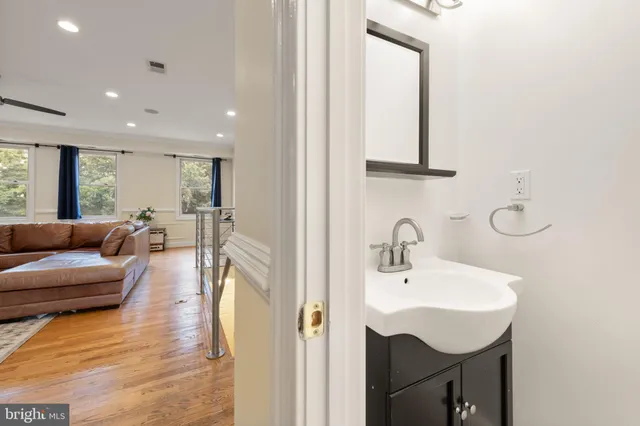 a kitchen with stainless steel appliances granite countertop a refrigerator a stove top oven a sink dishwasher and white cabinets with wooden floor