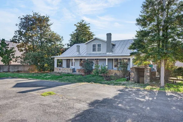 a front view of a house with a yard and trees