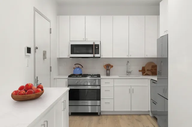 a kitchen with a stove and white cabinets