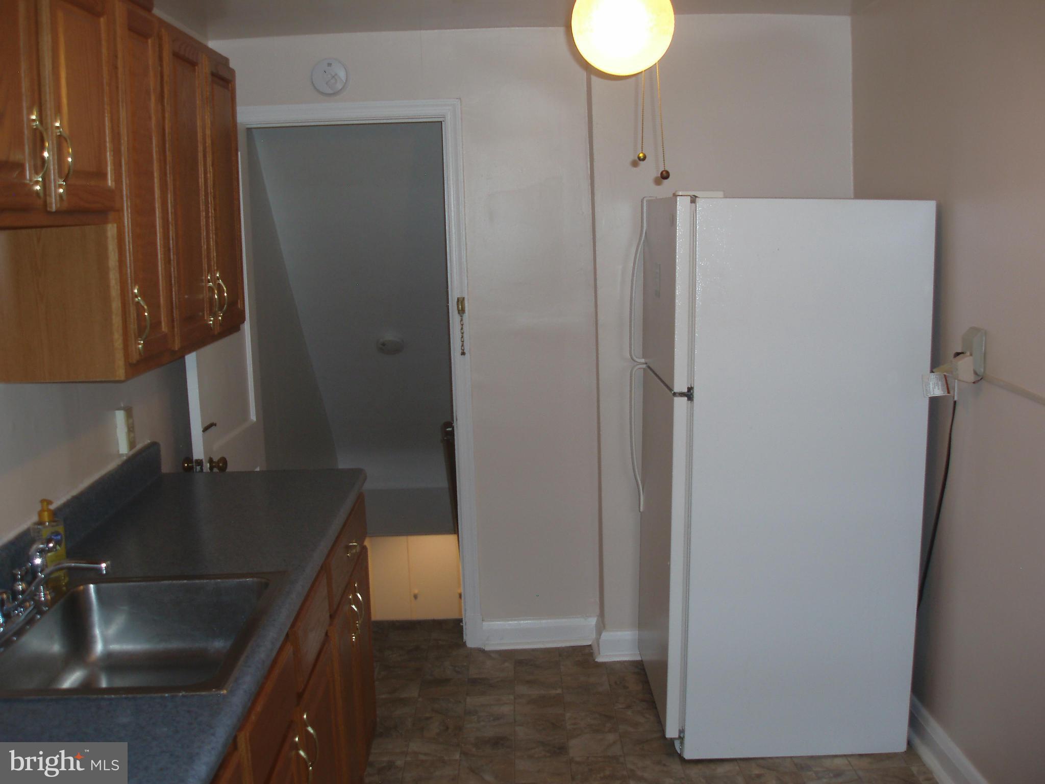 1417 Barrett Road Baltimore, MD 21207 - Photo 5 of 18 a kitchen with a sink and a refrigerator